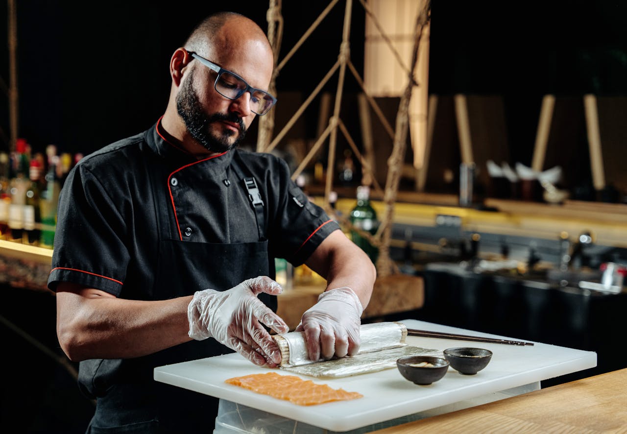 Professional chef making sushi with precision. Culinary expertise displayed in a modern kitchen setting.
